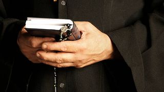 calugar care tine in mana biblia