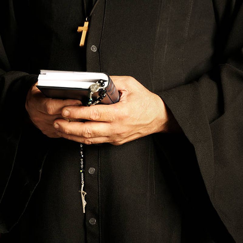 calugar care tine in mana biblia