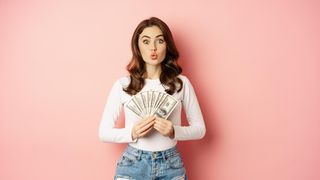 fata care tine bancnote de dolari in mana