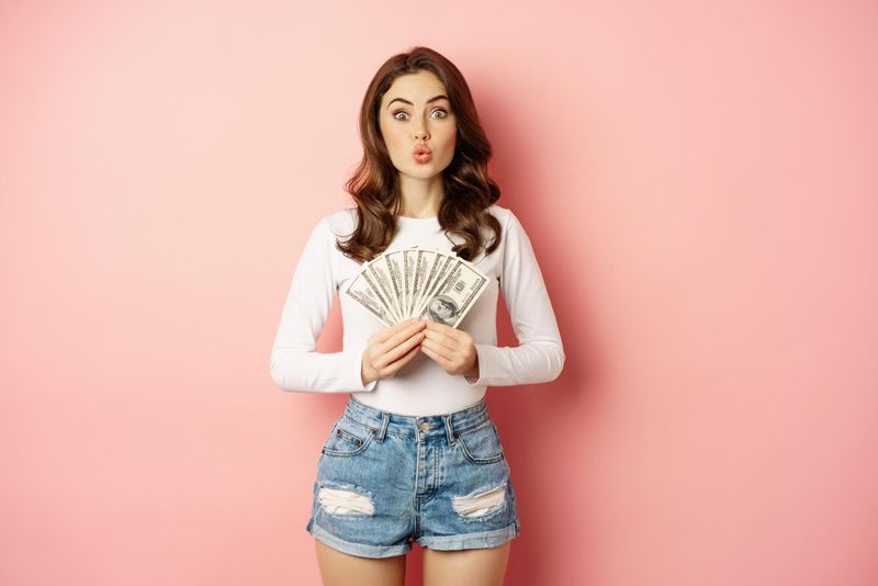 fata care tine bancnote de dolari