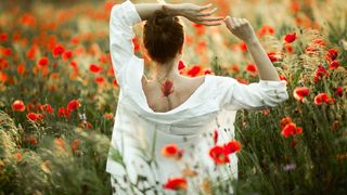 femeie care sta cu spatele printre flori