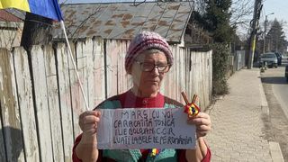 O femeie de 74 de ani protestează singură, &icirc;n fața casei, &icirc;n Iași: "Nu &icirc;mi este frică de ei". Bătr&acirc;na are doar o singură dorință