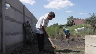 Tatăl face treburi în curte cu fiul său