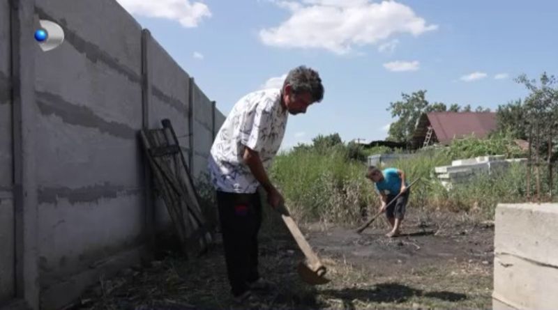 Tatăl face treburi în curte cu fiul său