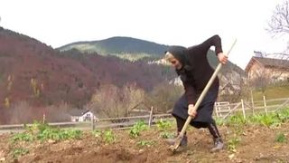 Eugenia Cotinghiu făc&acirc;nd treburi prin curte