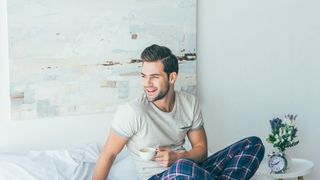 Barbat intr-un dormitor decorat cu un tablou abstract 