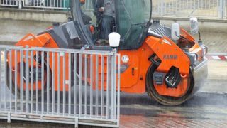 Hunedoara: Mai multi muncitori asfalteaza de zor pe o ploaie torentiala.