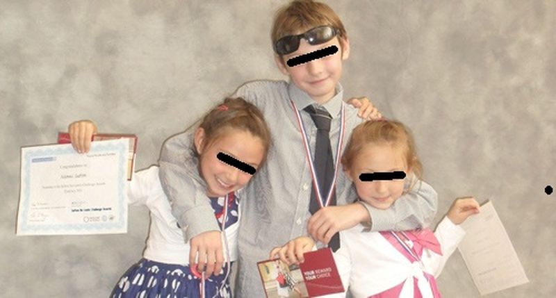Cei trei copii ai romancei, pe vremea in care stateau cu mama lor, aratand diplomele de la scoala