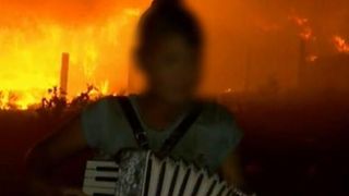 Imagini halucinante. Un baiat canta la acordeon si da dedicatii, iar in spatele lui flacarile erau cat un bloc cu 8 etaje