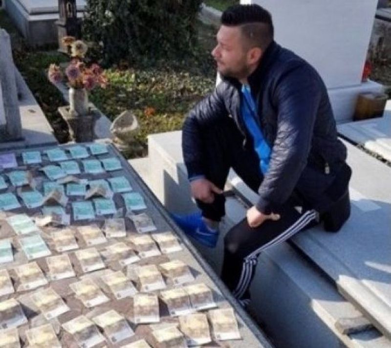 Miculescu s-a fotografiat in cimitir, acoperind cu bancnote un loc de veci