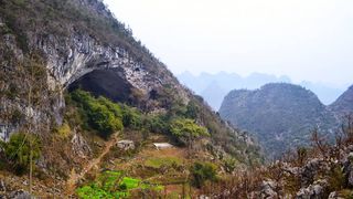 In China exista o pestera atat de mare incat 100 de oameni traiesc acolo. Au scoala si un teren de sport! Imaginile sunt incredibile