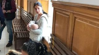 Imagine dureroasa pe holurile Judecatoriei din Cluj. O mamica isi alapteaza copilul inainte sa fie dusa in arest