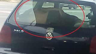 Inconstienta maxima! Copil fotografiat cand doarme intre luneta si bancheta din spate a masinii