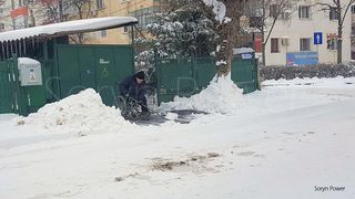 Fotografie emotionanta! Un barbat imobilizat in scaunul cu rotile a iesit, in frig, sa deszapezeasca trotuarul din fata casei
