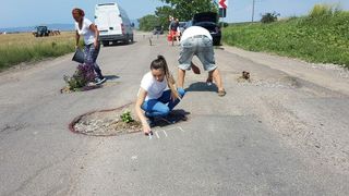 Protest inedit pe un drum judetean din Vrancea! Mai multi localnici au incercuit gropile din asfalt si au plantat flori si pomi in ele!