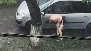 Imagini virale! Un barbat si-a spalat masina, in fata blocului, in timpul codului portocaliu de ploi torentiale