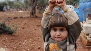 O fotografie cat 1000 de cuvinte! Baietelul din imagine credea ca va fi impuscat cand a vazut obiectivul aparatului si a ridicat mainile pentru a se preda