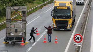 Migrantii de la Calais au o noua metoda prin care incearca sa ajunga in Marea Britanie. Blocheaza traficul intentionat pentru a distrage soferii. Cand acestia ies din masini, iau cu asalt camioanele