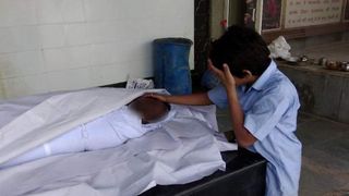 Copilul care plange langa trupul neinsufletit al tatalui sau. Povestea teribila dintr-o familie din India