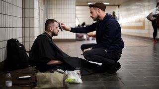 Un tanar frizer ii tunde gratis pe oamenii strazii