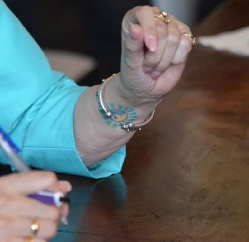 Iar la mana stanga are un tatuaj ca un soare