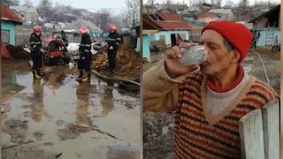 Tatal a sase copii savureaza un pahar de alcool  in timp ce pompierii ii scot apa din gospodaria inundata