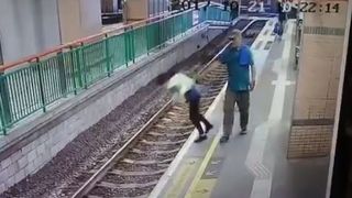 Momentul halucinant in care un barbat impinge o femeie pe sinele de cale ferata