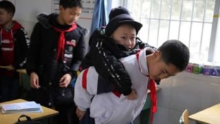 Un copil își duce prietenul bolnav, la școală, în spate