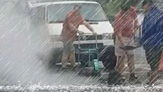 VIDEO | Ca la noi, la nimeni! Mai mulți muncitori, surprinși &icirc;n timp ce asfaltau gropile pe o ploaie torențială