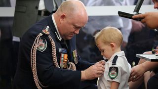 Povestea impresionantă a unui copil de doi ani. A fost decorat în locul tatălui său, un pompier ucis de flăcările din Australia