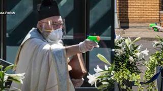 Imagini senzaționale. Un preot îi binecuvântează pe credincioși cu un pistol cu apă