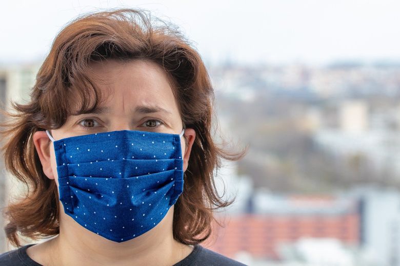 Femeie purtând masca de protecție Masca de protectie obligatorie