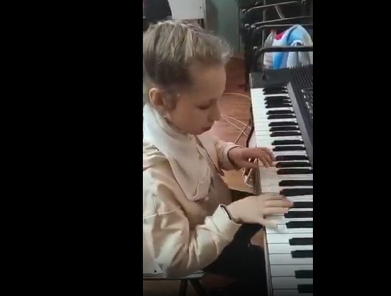 Fetita care canta la pian