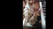 Fetita care canta la pian