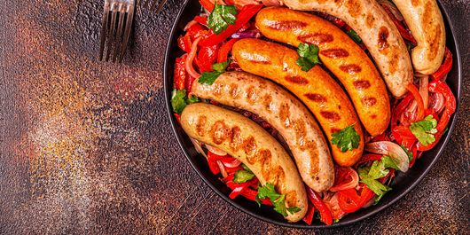 Cârnați pe grătar, serviți cu salată fresh. Gustul savuros al cârnaților la grătar și prospețimea salatei sunt perfecte!