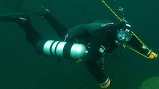 Un scafandru a intrat în apele unui lac pentru a strânge gunoaie, însă a descoperit un artefact vechi de 1.000 de ani