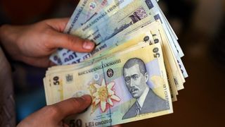 Salariul minim crește de la 1 iulie. Cu c&acirc;ți bani &icirc;n plus vor răm&acirc;ne rom&acirc;nii &icirc;n m&acirc;nă, ce &icirc;și pot cumpăra cu ei și alte ce implicații are majorarea